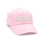 The Bits & Bows Sister Bow Hat is a light pink baseball cap with “SISTER” embroidered in bold white letters on the front and an adjustable tuckstrap for a comfortable fit—ideal for family outings.