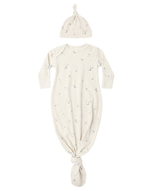 The Quincy Mae Baby Boys’ Knotted Baby Gown + Hat Set features a cream-colored gown and matching hat, both made from soft organic rib knit and adorned with a charming moons and stars pattern.