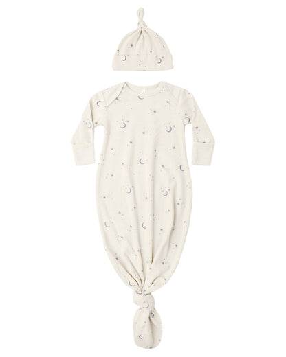 The Quincy Mae Baby Boys’ Knotted Baby Gown + Hat Set features a cream-colored gown and matching hat, both made from soft organic rib knit and adorned with a charming moons and stars pattern.
