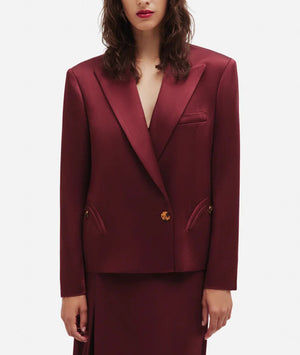 Someone wearing a burgundy Novalis Sunfire Blazer by Blaze Milano with wide lapels and gold buttons, standing against a plain white background.