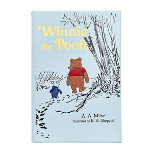 Graphic Image’s “Winnie the Pooh” book cover features Pooh and Piglet walking under trees—a charming illustration from the classic tale.