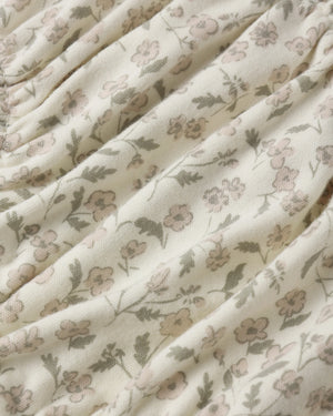 Close-up of the Quincy Mae Baby Girls’ Gathered Bloomer, crafted from cream-colored fabric with a gathered texture and adorned with a delicate small floral print in muted pink, green, and beige—perfectly designed with elasticated leg openings for adorable comfort.