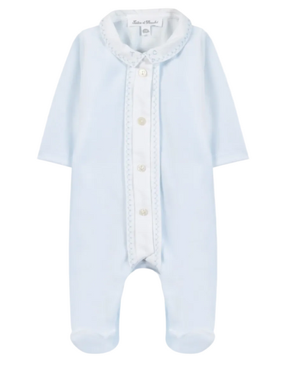 The Baby Boys’ Velvet Pointed Collar Pajamas by Tartine et Chocolat are light blue sleepwear featuring long sleeves, footed legs, a white button placket, and a decorative pointed collar. The garment is displayed flat against a white background.