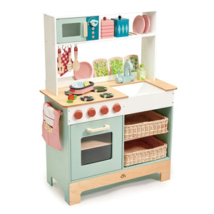 The Tender Leaf Toys Kitchen Range is a delightful wooden toy kitchen set featuring a stove, oven, sink, shelves, dishes, utensils, and baskets—perfect for inspiring hours of imaginative play for any mini chef. A pink oven mitt hangs on the side, while the countertop includes a pretend iron and wooden accessories like toy vegetables to enhance creative play in this charming pretend kitchen.