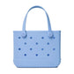 The Bitty Bogg® Bag by Bogg Bags is a compact, light blue tote featuring round holes on the sides and two sturdy handles. Crafted from a flexible, rubber-like material, this washable bag is both stylish and easy to clean.