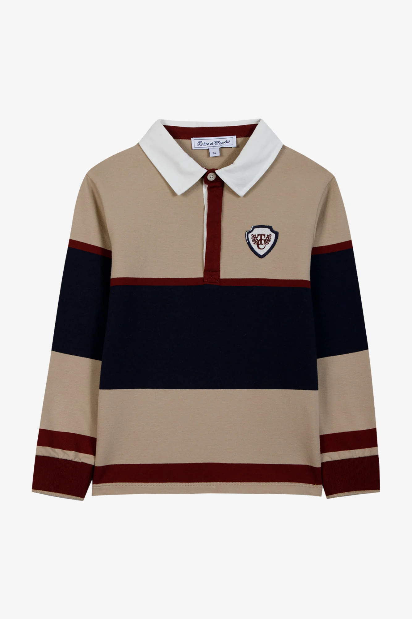 Boys’ Pointed Collar Stripes Polo Shirt by Tartine et Chocolat features tan, navy, and burgundy stripes, a classic white pointed collar, button placket, and an embroidered crest patch on the left chest. Expertly crafted from soft cotton for lasting comfort, this polo shirt blends timeless style with sporty sophistication.