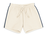 Konges Slojd Baby Boys’ and Boys’ Florian Shorts in beige, featuring a drawstring waist and navy blue side stripes, crafted from organic cotton and displayed flat against a white background.
