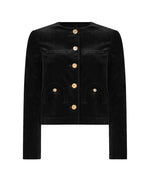 The Jealousy Shamo Bolero by Blaze Milano is a black cotton velvet jacket featuring long sleeves, a round neckline, gold-toned front buttons, and two curved pockets on each side.