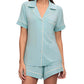 Someone dressed in the Eberjey Gisele Relaxed Short PJ Set: light blue short-sleeved pajamas with white trim, a buttoned shirt with a functional pocket, and matching shorts for comfort.