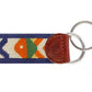 The Smathers & Branson Pompano Key Fob by Smathers & Branson features a multicolored, patterned fabric strip with brown leather trim, attached to two metal key rings. This stylish and vibrant accessory is designed to easily fit in your pocket while showcasing your colorful personality.