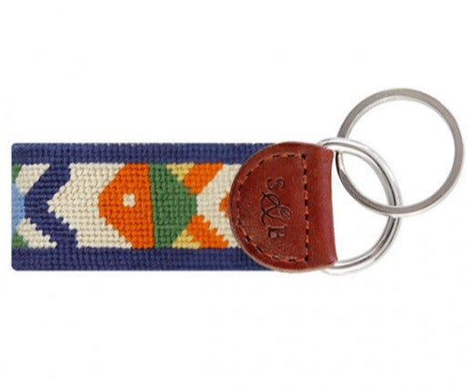 The Smathers & Branson Pompano Key Fob by Smathers & Branson features a multicolored, patterned fabric strip with brown leather trim, attached to two metal key rings. This stylish and vibrant accessory is designed to easily fit in your pocket while showcasing your colorful personality.