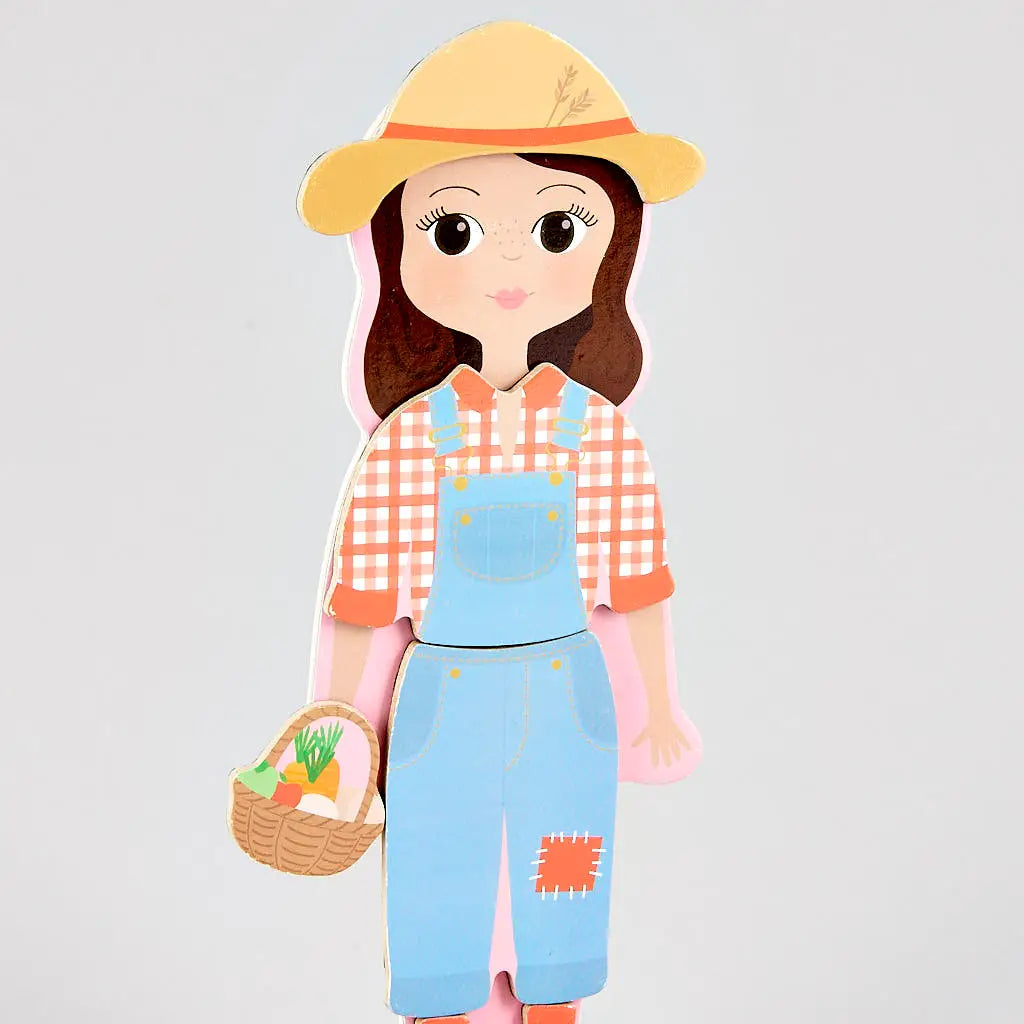 Here’s a revised sentence using your product data: The Floss and Rock Sophia Magnetic Dress Up Character features an illustration of a girl wearing a straw hat, plaid shirt, and blue overalls while holding a basket of vegetables—perfect inspiration for role play or as an engaging dress up set—standing against a plain background.
