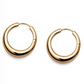 The Andrea Earrings by Lie Studio are classic gold hoops with a smooth, polished finish, displayed on a white background—perfect for elevating your look.