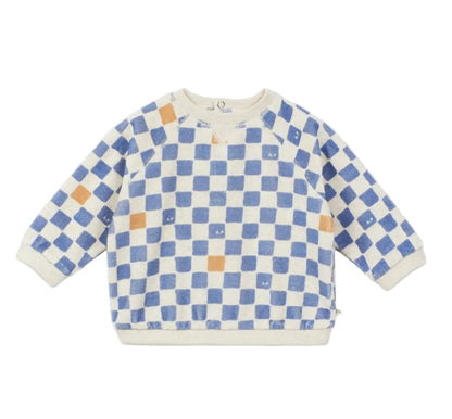 The Arsene & Les Pipelettes Baby Sweatshirt is made from soft organic fleece and features a cream base with a blue checkerboard pattern, accented by scattered orange squares and finished with a classic crew neckline.