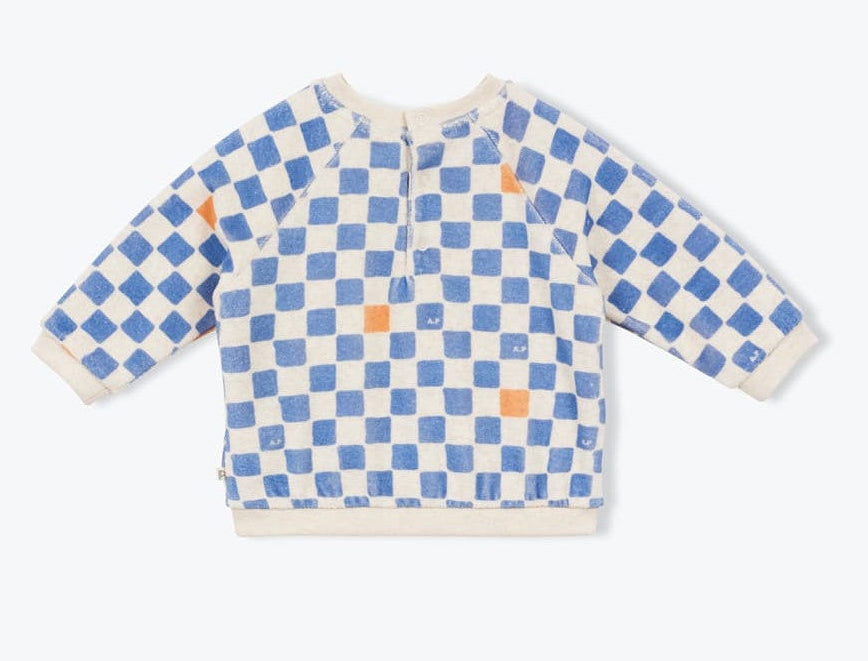 The Arsene & Les Pipelettes Baby Sweatshirt is a long-sleeve top made from soft organic cotton fleece, featuring a blue and orange checkered pattern on a cream background and shown laid flat on a plain light surface.