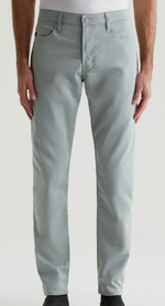 Someone wearing AG Jeans' Performance Airluxe™ Modern Slim pants in light gray and a white shirt, standing with arms relaxed at their sides.