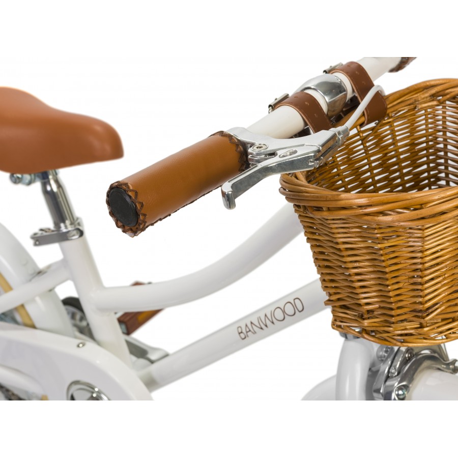 A Banwood classic children's bicycle with a wicker basket and handlebars.