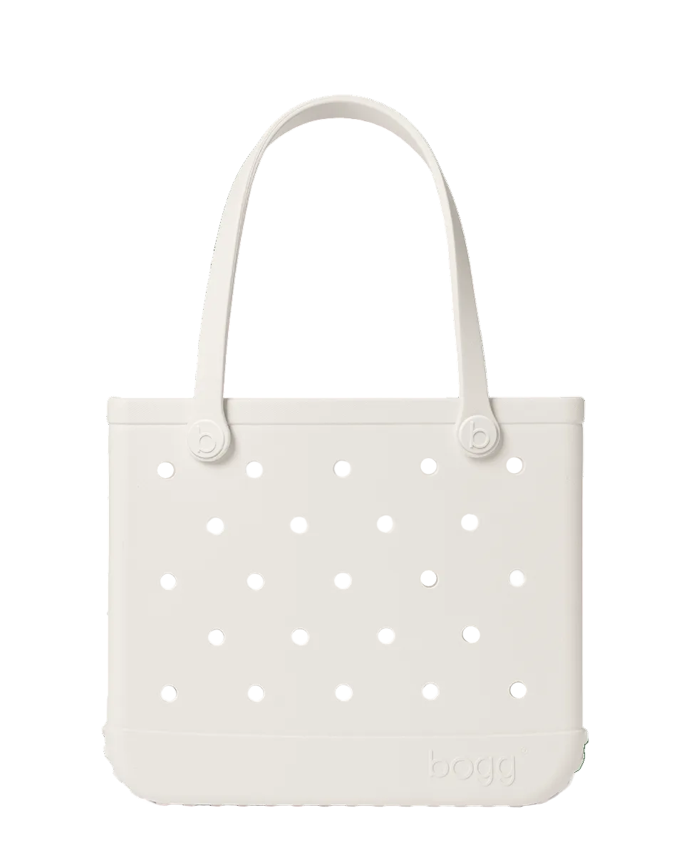 A white, rectangular Baby Bogg® Bag by Bogg Bags features round holes, two sturdy handles, and the word “bogg” embossed at the bottom right—this durable, washable tote is also easy to customize to match your style.