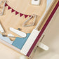 Enjoy hours of screen-free play with the Coco Village Wooden Play Pinball Machine—a charming, vintage-inspired wooden pinball toy featuring flippers, bumpers, a plunger, and a metal ball on a light-colored board. Decorated with red triangular flag designs reminiscent of a classic circus arcade game, this delightful pinball machine brings timeless fun to any playroom.