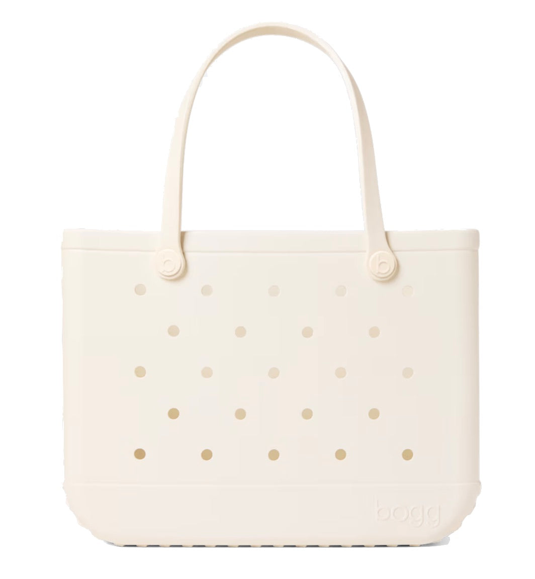 A beige, rectangular Original Bogg® Bag tote by Bogg Bags features rounded handles and small circular holes on its surface. The word “bogg” is embossed on the bottom right corner, making this washable bag ideal for use as a beach tote.