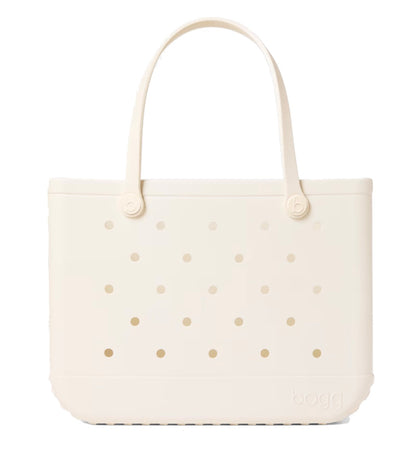 A beige, rectangular Original Bogg® Bag tote by Bogg Bags features rounded handles and small circular holes on its surface. The word “bogg” is embossed on the bottom right corner, making this washable bag ideal for use as a beach tote.