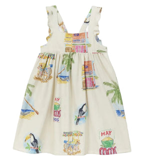 The Girls' Cocos Frios Dress by Arsene & Les Pipelettes is a cream-colored sleeveless cotton twill dress featuring ruffled straps and vibrant tropical prints of toucans, palm trees, buildings, and carts—perfect for a stylish look.