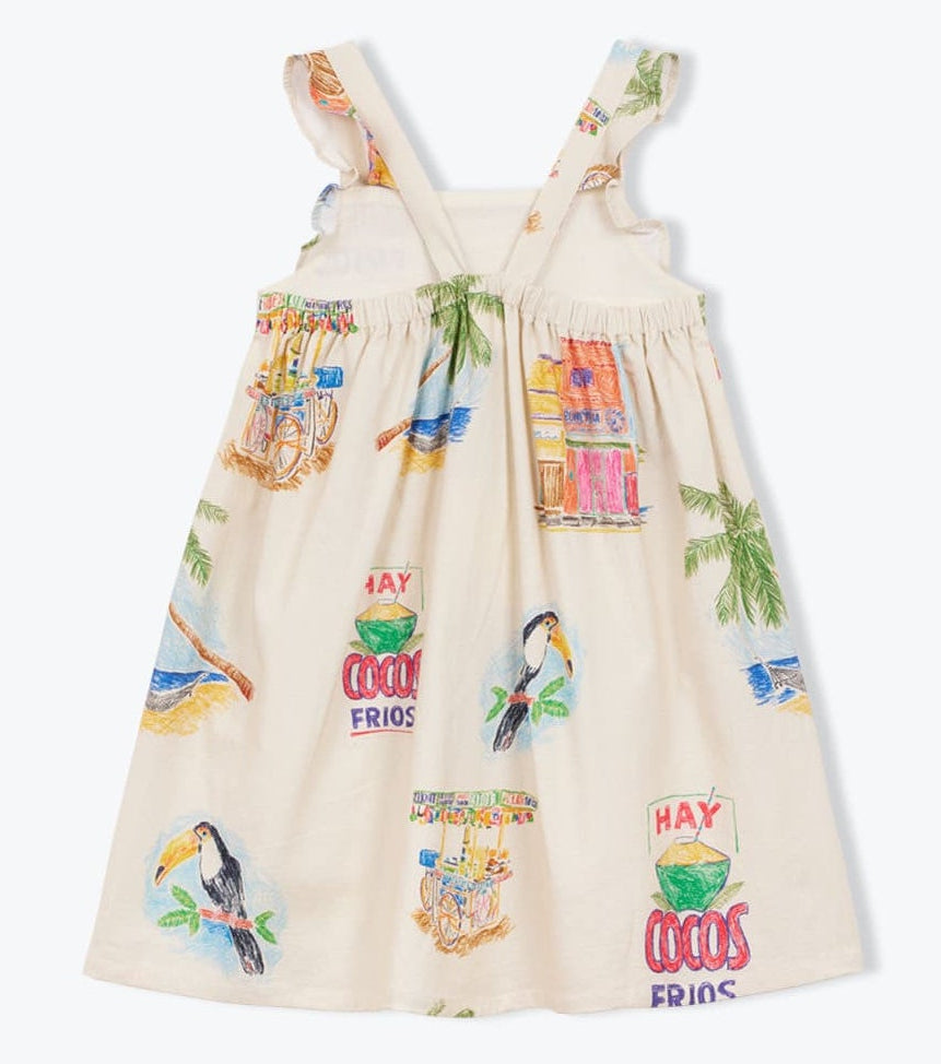 The Girls' Cocos Frios Dress by Arsene & Les Pipelettes is a sleeveless cream cotton twill dress with ruffled straps, adorned with vibrant tropical prints of toucans, palm trees, fruit stands, and "Hay cocos frios" signs—perfect for a playful look.