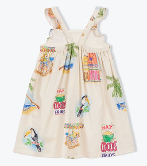 The Girls' Cocos Frios Dress by Arsene & Les Pipelettes is a sleeveless cream cotton twill dress with ruffled straps, adorned with vibrant tropical prints of toucans, palm trees, fruit stands, and "Hay cocos frios" signs—perfect for a playful look.
