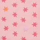 A pink background with red stars, plus one orange and one light pink star—ideal for highlighting the Magnetic Me Baby Girls' Cosmic Confetti Bow Headband, crafted from soft modal fabric.