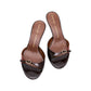The Crackle Shine Kitten Heel by Dorothee Schumacher is a pair of dark brown open-toe slip-on heeled sandals with a thin strap and signature buckle detail, set on a white background. Features a chic kitten heel for added elegance.