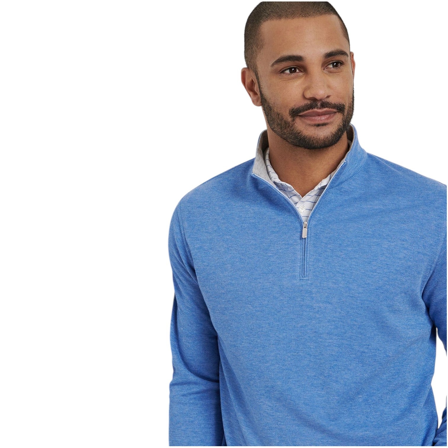 A man with short hair and a beard wears the Peter Millar Crown Comfort Pullover, a blue cotton-modal quarter-zip, over a collared shirt, gazing slightly left against a white background.
