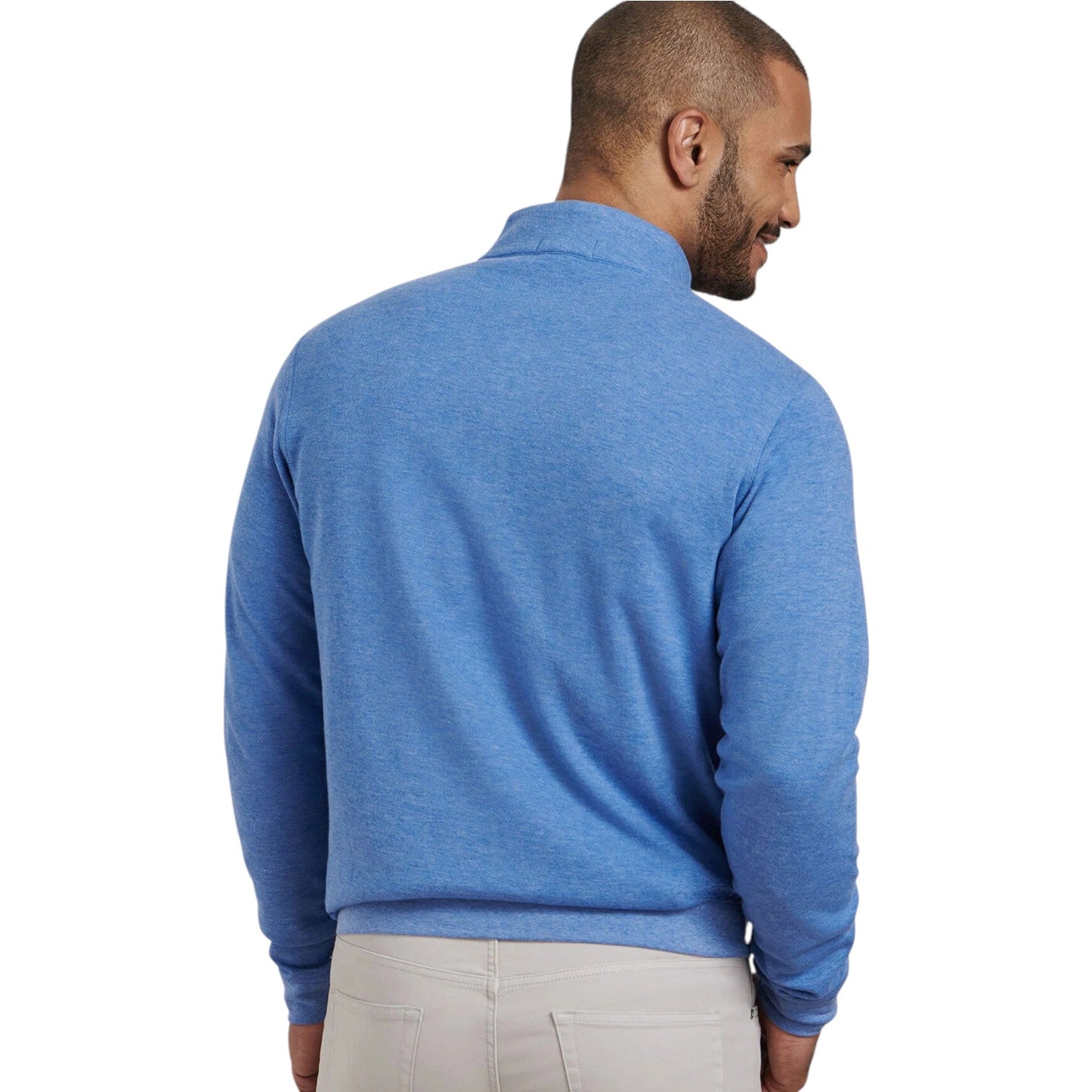 A man, back to the camera, models the Peter Millar Crown Comfort Pullover—a light blue quarter-zip and perfect lightweight layer—paired with light pants against a white background.