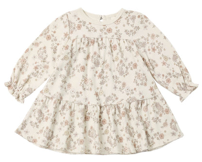 The Quincy Mae Baby Girls’ and Girls’ Tiered Jersey Dress is a long-sleeve, cream-colored dress for toddlers featuring a ruffled hem and an all-over delicate floral print in soft pink and beige tones.