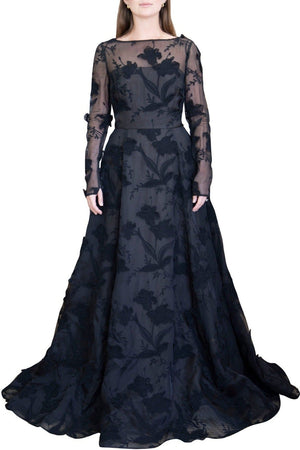 A person wears a floor-length, long-sleeve Jason Wu Embroidered Organza Gown with floral patterns and lace appliqués from the Jason Wu Collection. The dress is semi-sheer at the top and fitted at the waist with a flared skirt.