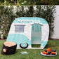 An Asweets Mini Camper Play House with a "Road Trip" banner is in a camping scene on grass near a white fence and greenery, featuring a plush log, toy campfire, and children's book.