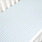 A Gooselings white crib comes with an OEKO-TEX certified mattress and a Picnic Gingham Blue Crib Sheet in light blue and white checkered cotton sateen.