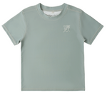 The Rylee & Cru Baby Boys' and Boys' Short Sleeve Rashguard features light gray fabric, white stitching, a sea green palm tree and wave chest graphic, and offers UPF 50+ sun protection.