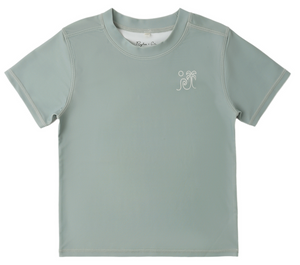 The Rylee & Cru Baby Boys' and Boys' Short Sleeve Rashguard features light gray fabric, white stitching, a sea green palm tree and wave chest graphic, and offers UPF 50+ sun protection.