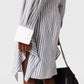 A person is wearing the Stella McCartney Long Sleeve Pinstripe Shirt Dress, featuring blue and white stripes with large white cuffs, and is holding a black chain-strap bag.