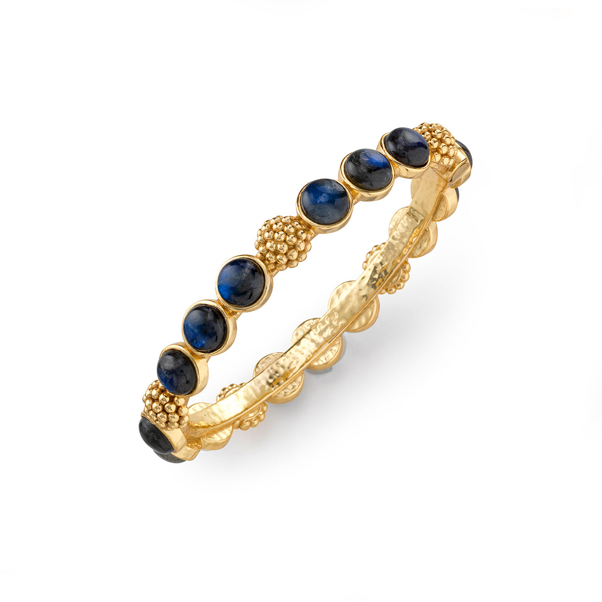 The Berry Gem Hinged Bangle by Juliska Capucine De Wulf features alternating blue gemstone cabochons and small gold bead clusters, showcasing regal gem-drop elegance on a white background.