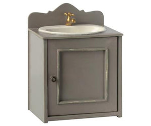 An elegant Maileg Miniature Bathroom Sink featuring a compact, grey vanity adorned with a vintage metal basin and a golden faucet.