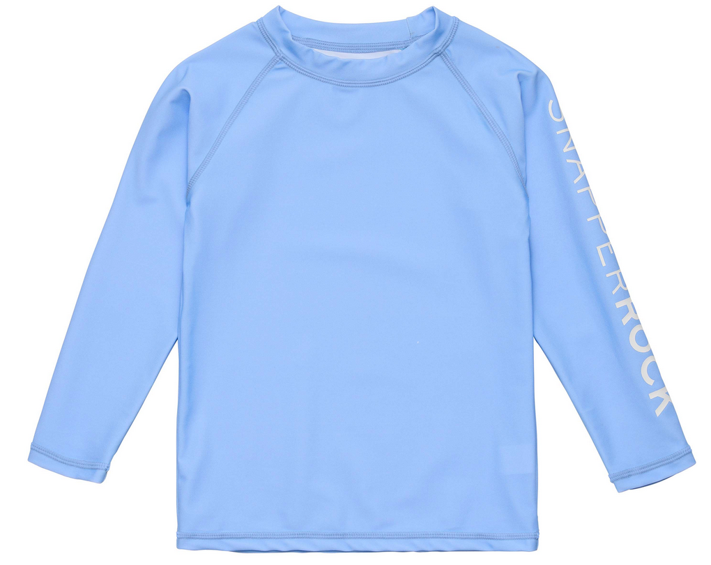 The Snapper Rock Boys' LS Rash Top in light blue features "SNAPPERROCK" in white on the left sleeve, designed for sun safety, and is shown on a plain white background.