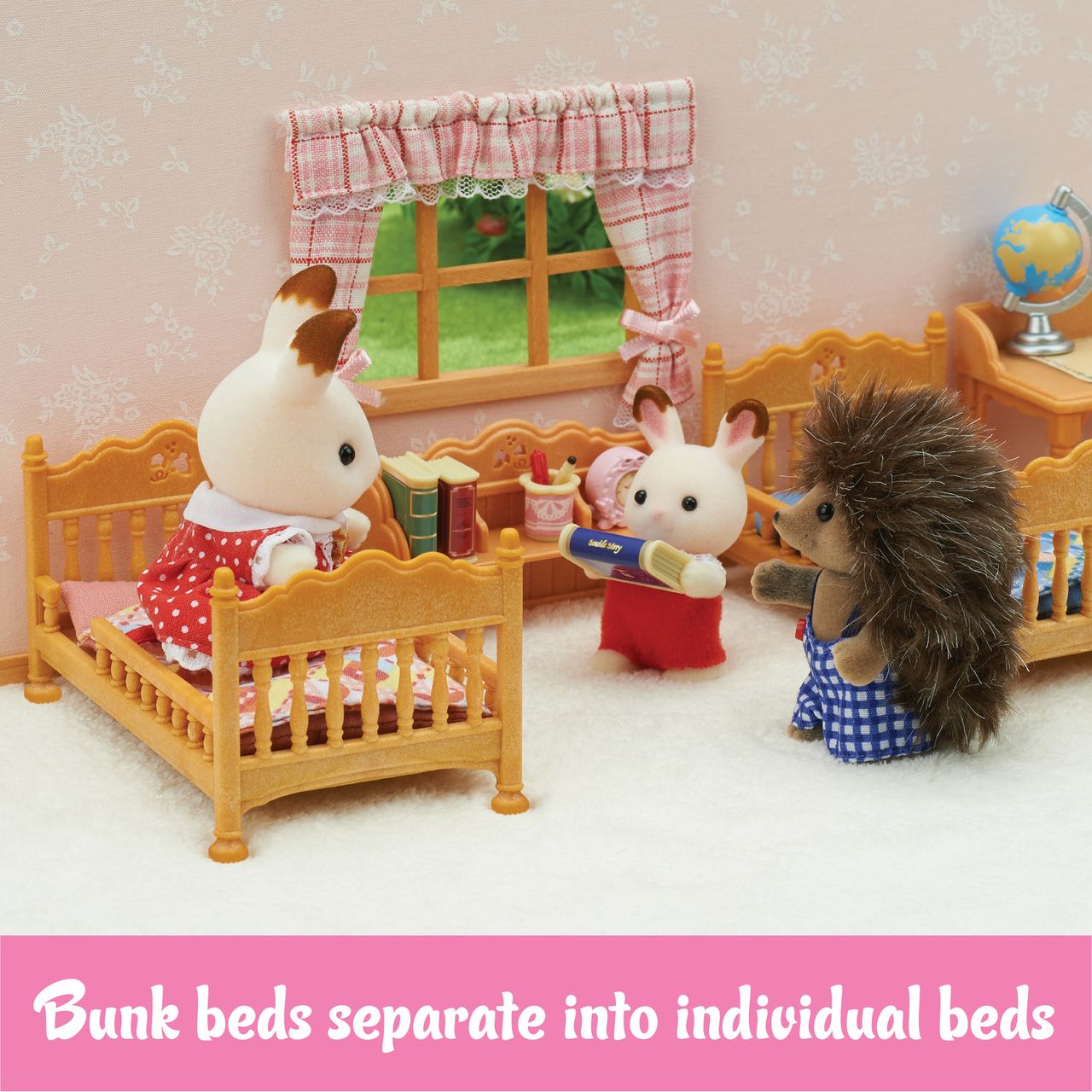Three animal figurines stand in a toy bedroom with two wooden beds, books, and a window. Featuring charming Calico Critters furniture, the Children’s Bedroom Set by Calico Critters includes bunk beds that can be separated into individual beds. A pink banner reads, “Bunk beds separate into individual beds.”.