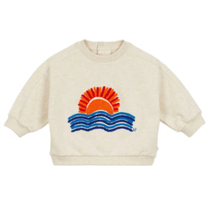 The Arsene & Les Pipelettes Baby Filippe Sweatshirt in beige showcases an embroidered orange sun rising over blue waves.