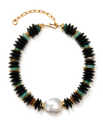 The Milano Collar by Lizzie Fortunato is a striking mixed-medium statement necklace, showcasing black, turquoise, and gold discs accented by a large white freshwater pearl at the center. Finished with a gold adjustable chain clasp, this eye-catching collar is perfect for elevating any look.
