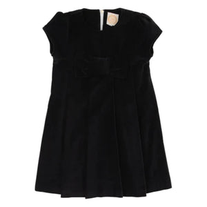The Beaufort Bonnet Company’s Girls' Velveteen Darcy Dress features short sleeves, a black velveteen finish, a front bow detail, and back zipper closure, shown against a white background.