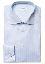 A folded, wrinkle-free Eton Light Blue Reverse Striped Signature Twill Shirt, Contemporary Fit with white buttons and a brand label reading "ETON" on the inside collar.