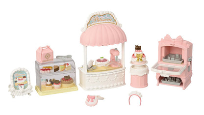 Introducing the Calico Critters Village Cake Shop Starter Set—a delightful miniature pink and white bakery playset featuring a display case, desserts, mixing stand, oven, and adorable baking accessories. Perfect for creating your own sponge cakes and practicing cake decorating skills, just like in a real cake shop!.