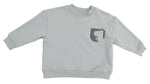 The Angel Dear Baby and Kids’ Drop Sleeve Sweatshirt is a light gray, long-sleeve top made from soft organic french terry, featuring a small chest pocket adorned with a simple dinosaur graphic.