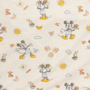 The Magnetic Me Baby Modal Bib 3-Pack features patterned fabric with Mickey Mouse in playful poses, breakfast foods like toast and eggs, pancakes, bananas, and cheerful sun designs—ideal for creating adorable infant bibs.